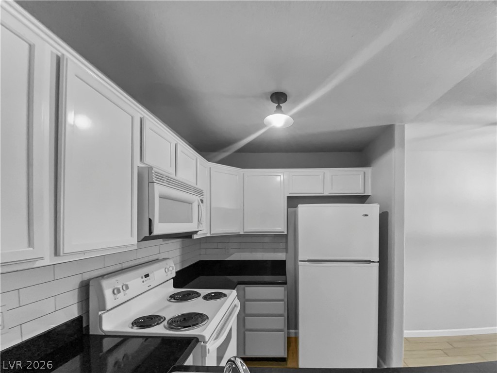 9325 West Desert Inn Road, Unit 278 Las Vegas, NV 89117 - Photo 4 of 17 A well-appointed kitchen offers white cabinetry, dark counters, and essential appliances.