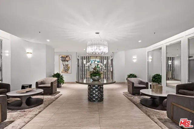 a living room with furniture a chandelier and a rug