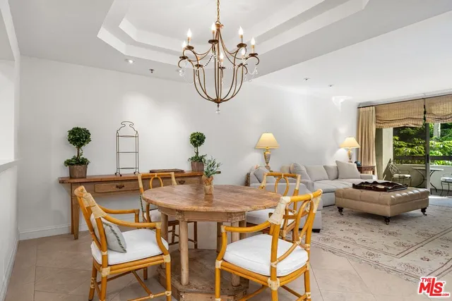 a dining room with furniture a potted plant and a chandelier