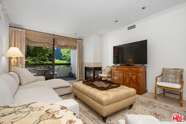 a living room with furniture a flat screen tv and a floor to ceiling window