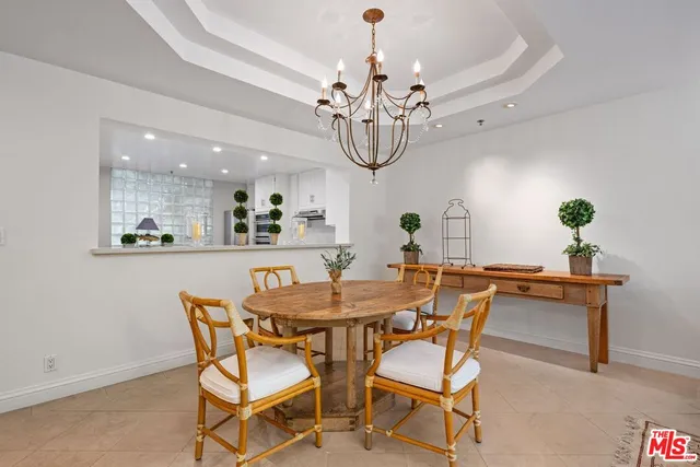 a dining room with chandelier fan and wooden floor