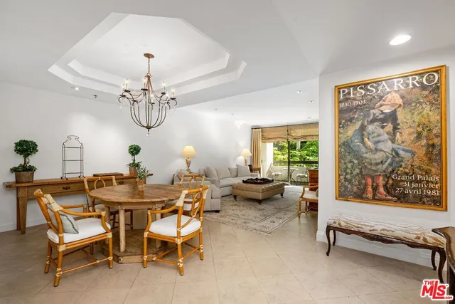 a view of a dining room with furniture a chandelier and a window