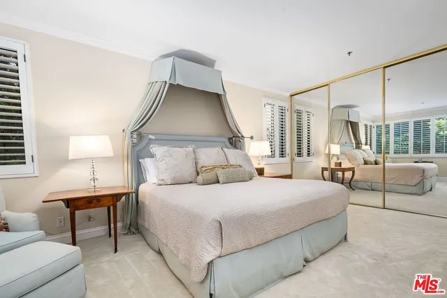 a bedroom with a bed and a large window