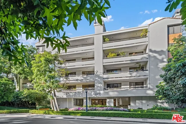 a front view of a multi story building with yard