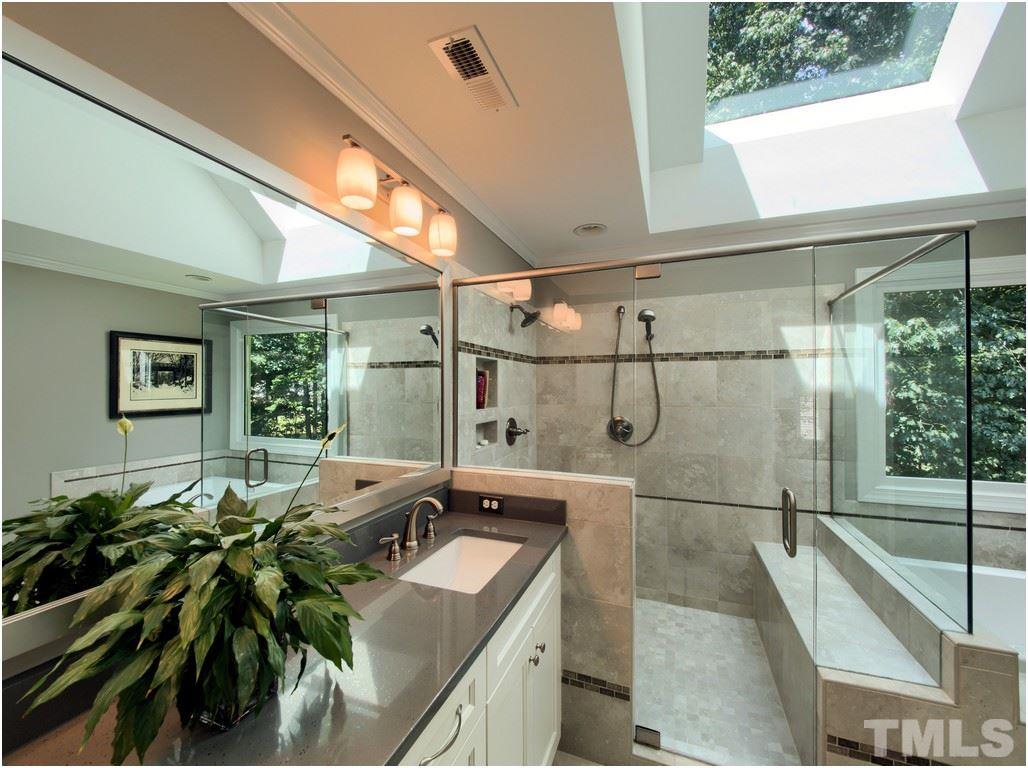 7908 Ogden Court Raleigh, NC 27613 - Photo 12 of 25 a bathroom with a granite countertop sink a mirror and shower