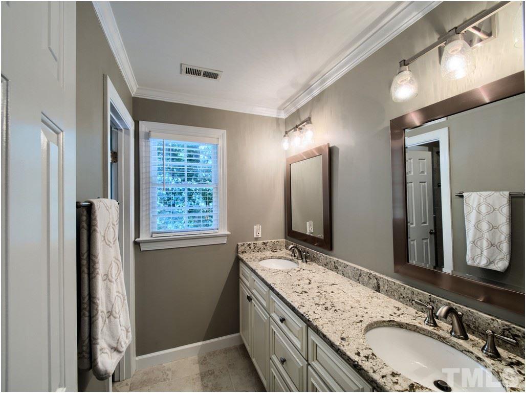 7908 Ogden Court Raleigh, NC 27613 - Photo 18 of 25 a bathroom with a granite countertop double vanity sink and large mirror