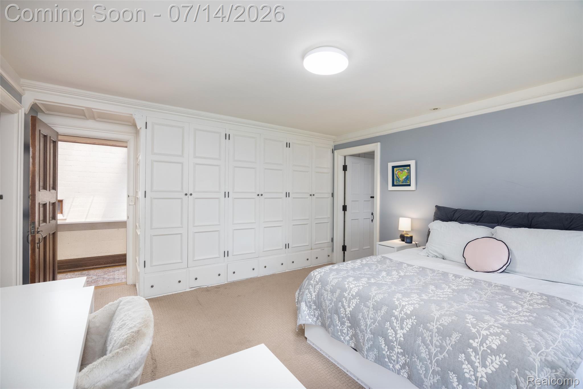 189 Cloverly Road Grosse Pointe, MI 48236 - Photo 51 of 96 Spacious room featuring extensive built-in white paneled cabinetry with black hardware, complementing a light blue accent wall