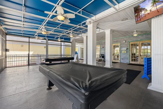 a view of a swimming pool with a yard and palm trees