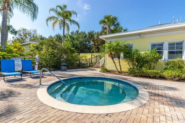 a view of swimming pool with lawn chairs and large trees