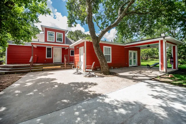 a view of a house with yard and large tree