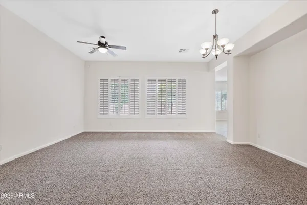 a view of an empty room with a chandelier fan