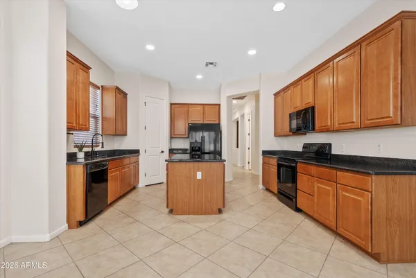 a large kitchen with stainless steel appliances granite countertop a stove a sink dishwasher and a refrigerator