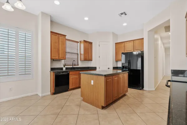 a kitchen with stainless steel appliances granite countertop a refrigerator and a stove top oven