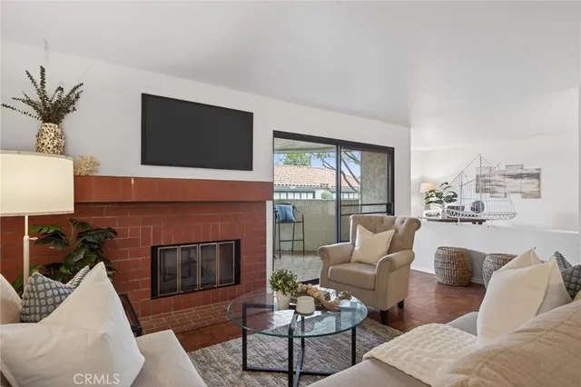 a living room with furniture floor to ceiling window and a fireplace