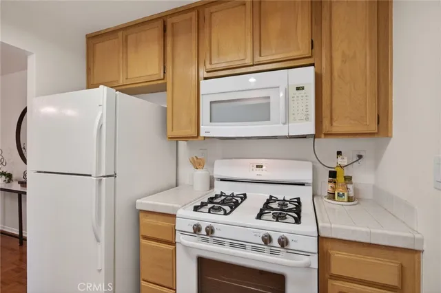 a white refrigerator freezer and a stove sitting inside of a kitchen