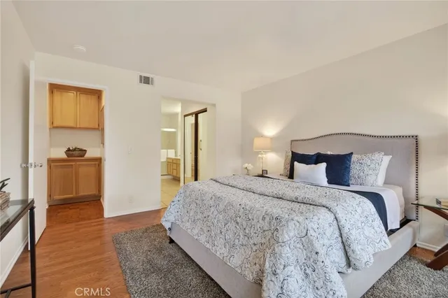 a spacious bedroom with a bed and a view of kitchen