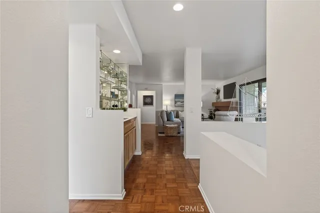 a living room with stainless steel appliances furniture a rug and a view of kitchen