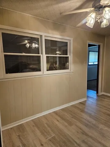 a view of empty room with a large window and wooden floor