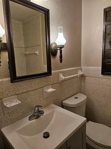 a bathroom with a sink a toilet and mirror