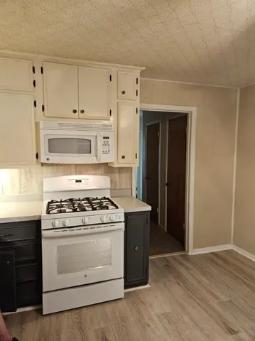 a kitchen with a stove and white cabinets