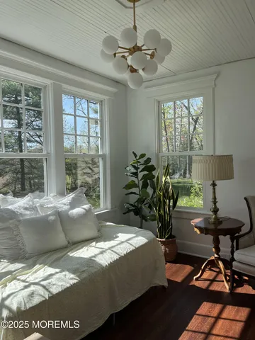 a view of a a dining room with furniture window and wooden floor