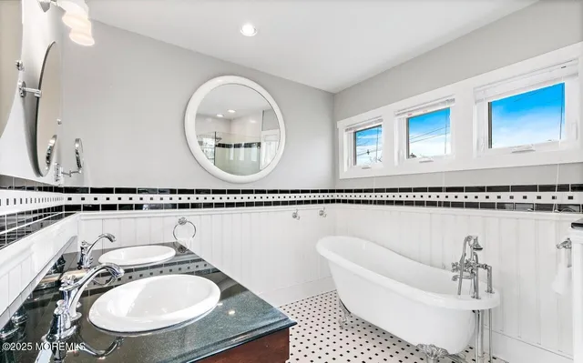 a bathroom with a sink a mirror and a bathtub with shower