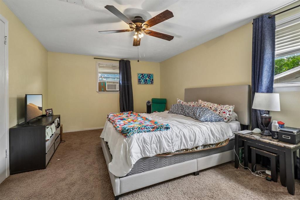 820 North Bowen Road Arlington, TX 76012 - Photo 21 of 40 a bedroom with a bed and a chandelier