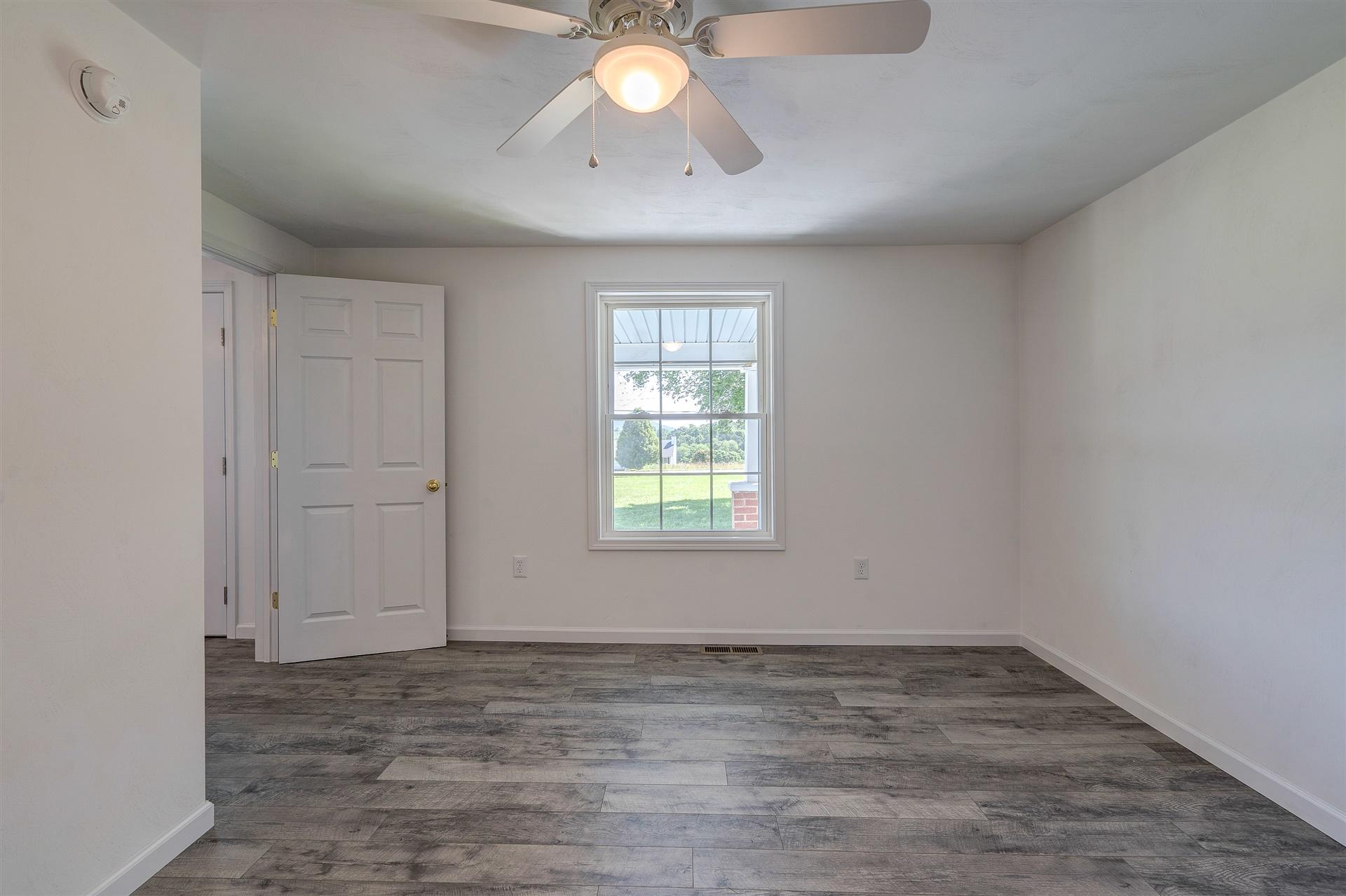 2137 Goodview Road Goodview, VA 24095 - Photo 12 of 37 wooden floor in an empty room with a window