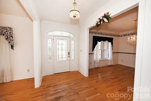 an empty room with wooden floor and mirror