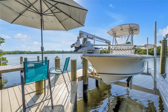 a view of a chairs and table in patio with a lake view