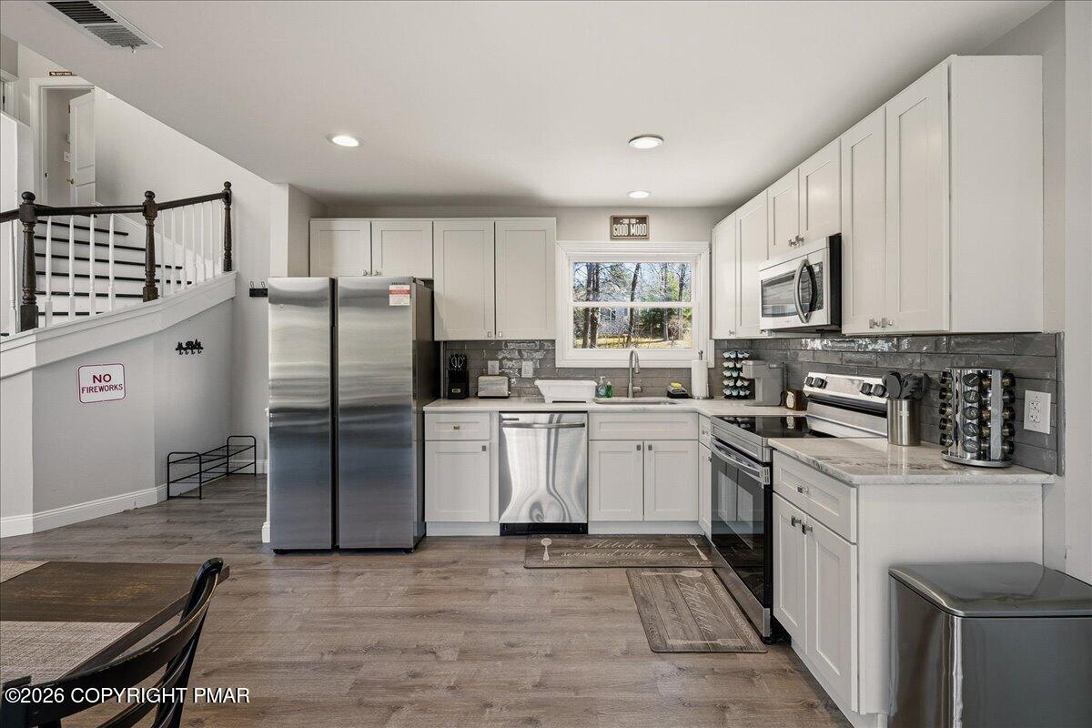 369 Sidney Avenue Pocono Summit, PA 18346 - Photo 7 of 32 a kitchen with white cabinets and stainless steel appliances
