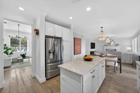 a kitchen view of a refrigerator and wooden floor