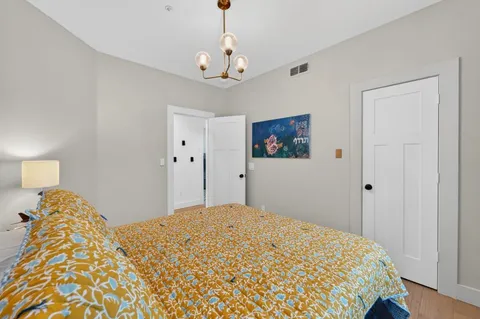a bedroom with a bed and a chandelier