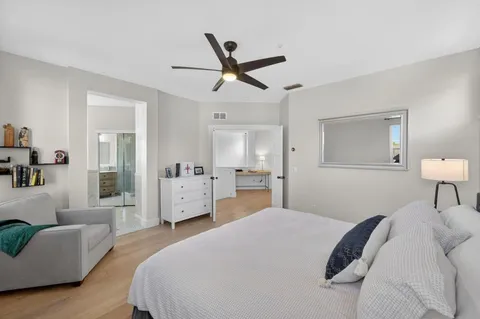 a bedroom with a large bed and a chandelier