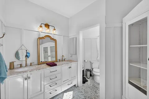a bathroom with a double vanity sink mirror and shower