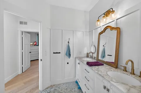 a bathroom with a granite countertop sink and a mirror