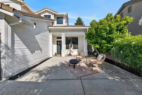 a view of a house with backyard sitting area and garden
