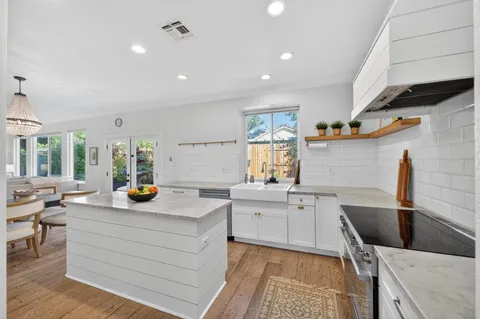a kitchen with white cabinets and sink