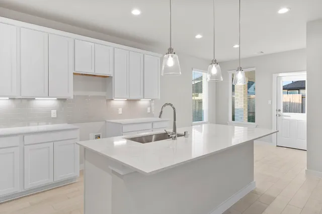 a kitchen with kitchen island a sink stainless steel appliances and cabinets