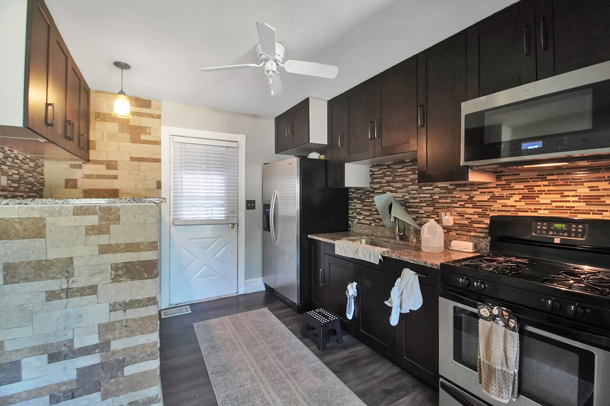 106 Louis Road Joliet, IL 60433 - Photo 5 of 14 a kitchen with stainless steel appliances kitchen island granite countertop a stove refrigerator and cabinets