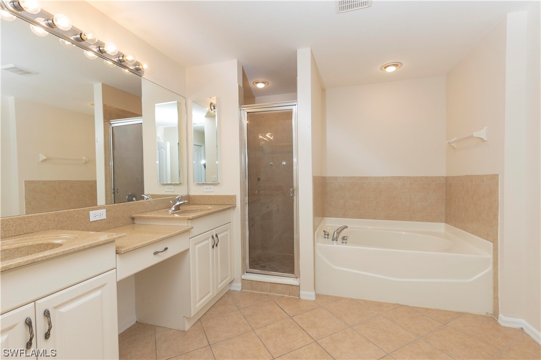12956 Stone Tower Loop Fort Myers, FL 33913 - Photo 14 of 26 a bathroom with a granite countertop sink a bathtub and a large mirror