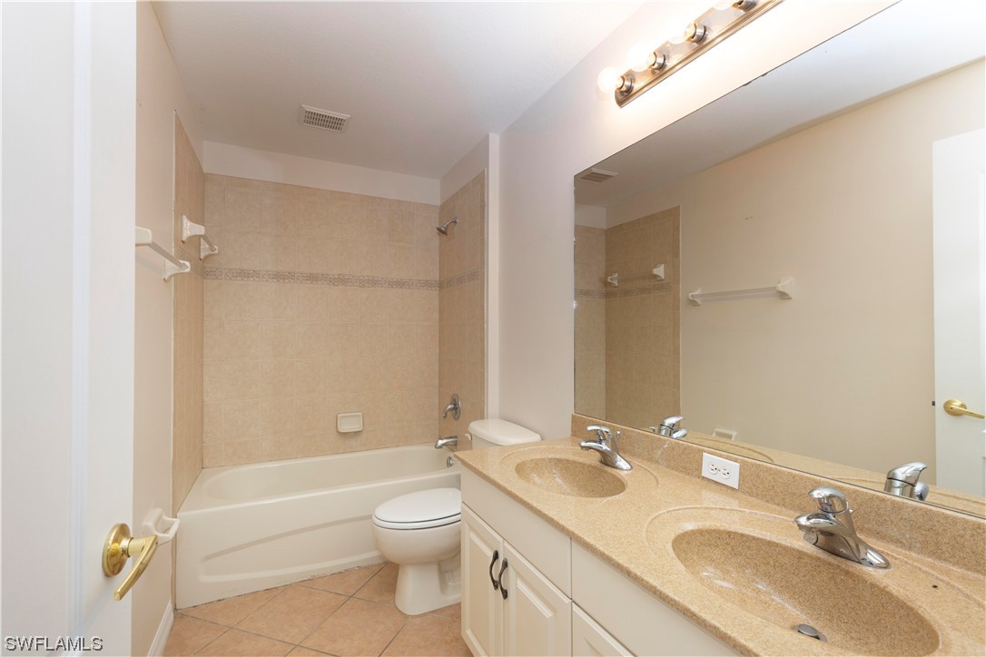 12956 Stone Tower Loop Fort Myers, FL 33913 - Photo 20 of 26 a bathroom with a granite countertop sink a toilet and a bathtub