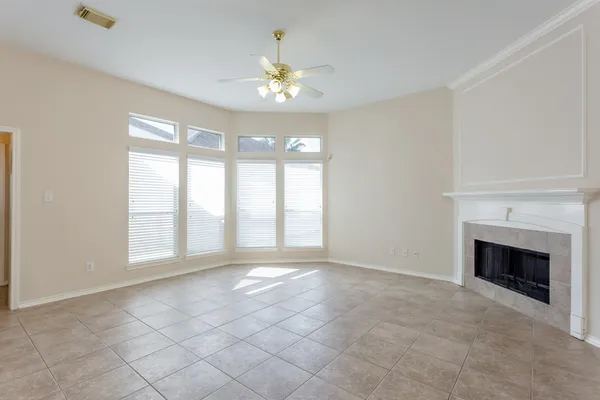 a view of a livingroom with a fireplace a chandelier and windows