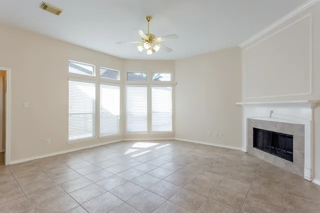 a view of a livingroom with a fireplace a chandelier and windows
