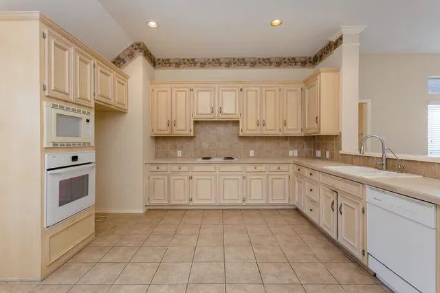 a kitchen with granite countertop cabinets and white appliances