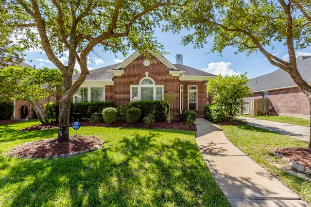 a front view of a house with a yard and trees