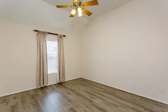 a view of an empty room with wooden floor