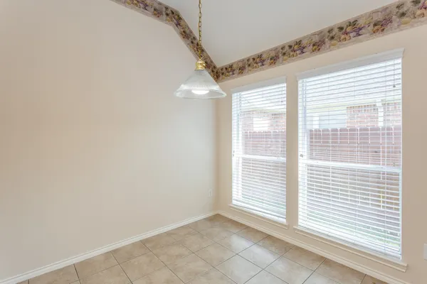 an empty room with wooden floor and window