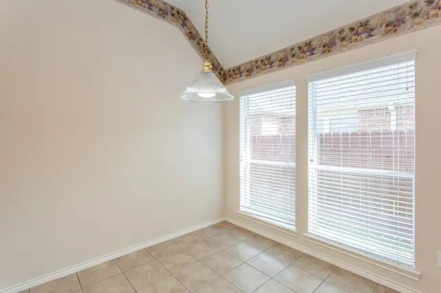 an empty room with wooden floor and window