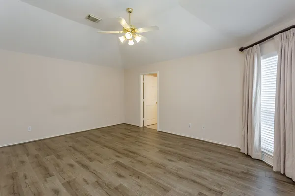 a view of an empty room with wooden floor